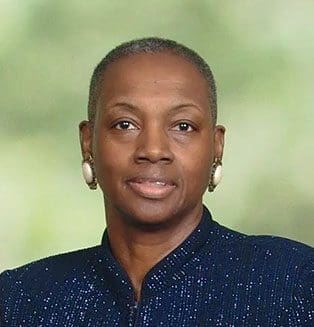 A woman with short hair is wearing a blue shirt.